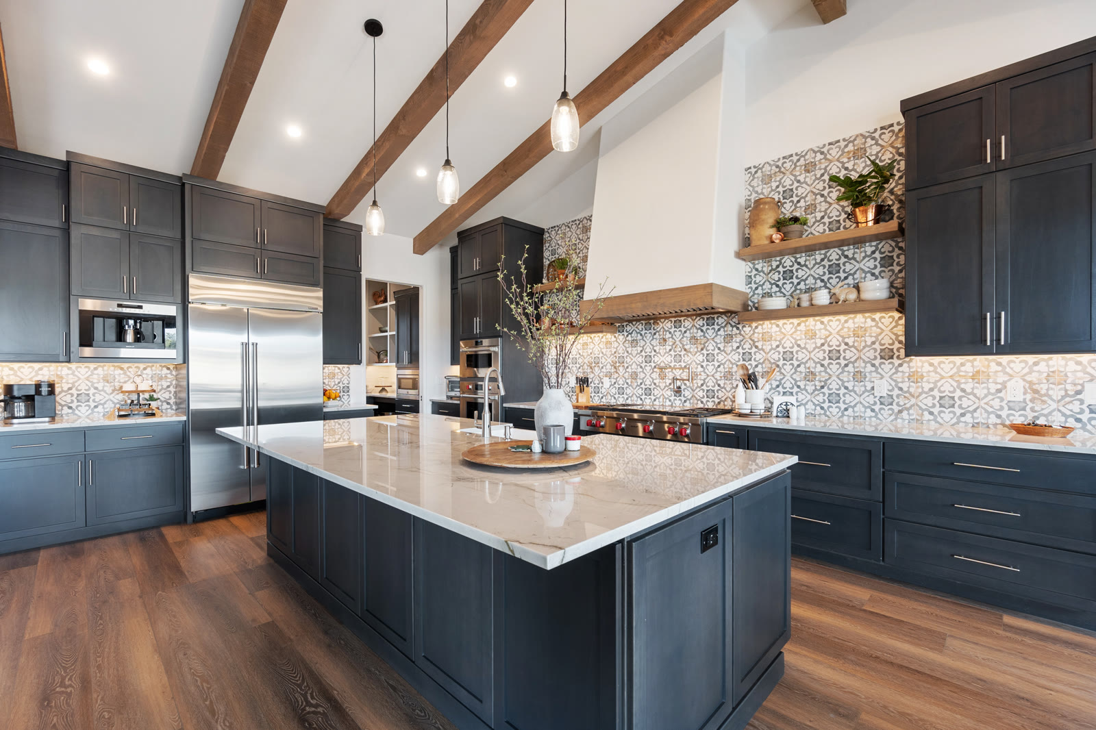 Finished kitchen with navy cabinets, wood ceiling beams, and patterned tile backsplash